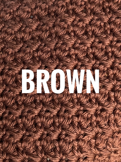 A close-up of a textured crochet washcloth swatch in a brown color, with the words 'BROWN' overlaid in large white text across the center.