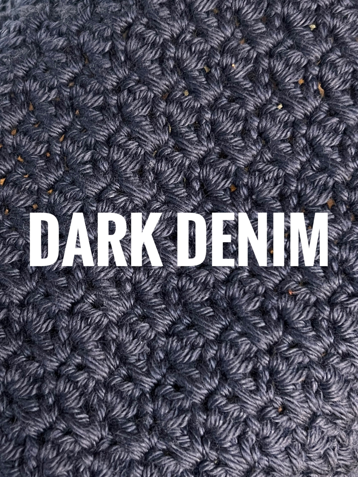 A close-up of a textured crochet washcloth swatch in a denim blue color, with the words 'DARK DENIM' overlaid in large white text across the center.