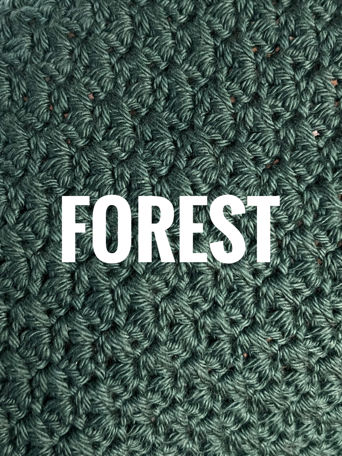 A close-up of a textured crochet washcloth swatch in a deep green color, with the words 'FOREST' overlaid in large white text across the center.