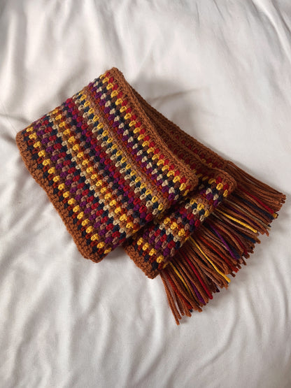 Multicolored crochet scarf with tassels on a white background