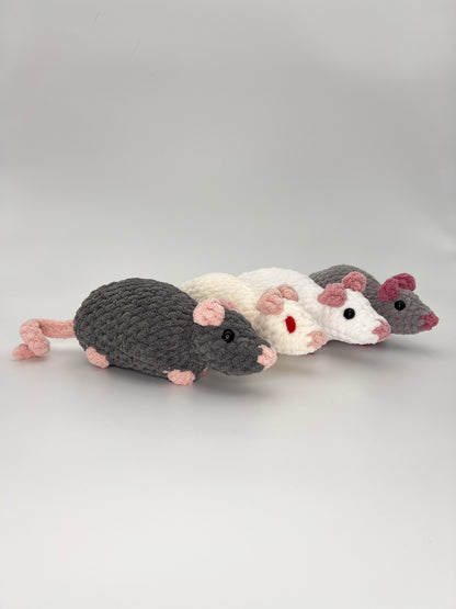Four crocheted rat/mouse toys in gray, white, and pink on a light gray background