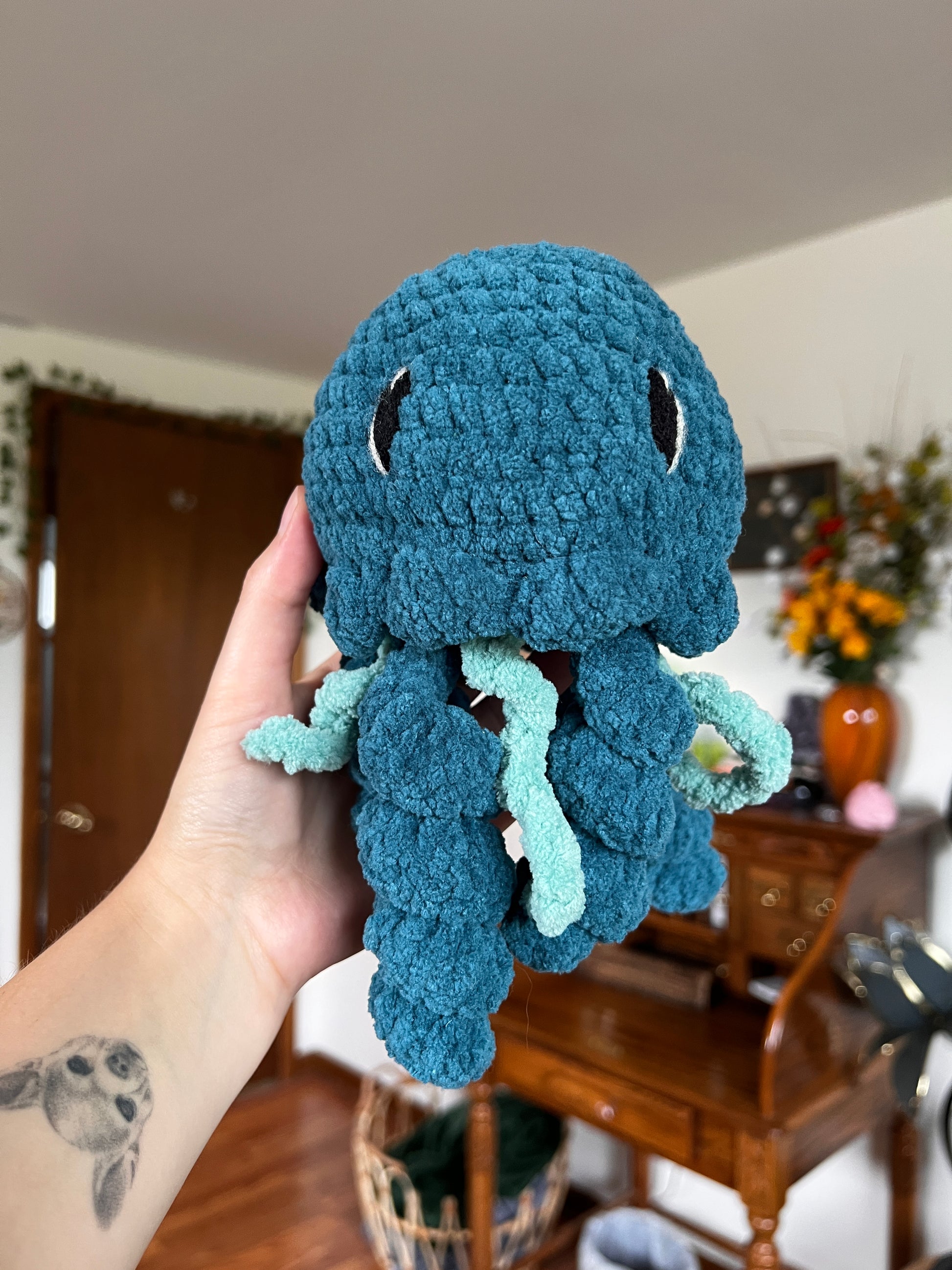 Crochet jellyfish in a turquoise and blue color with embroidered eyes