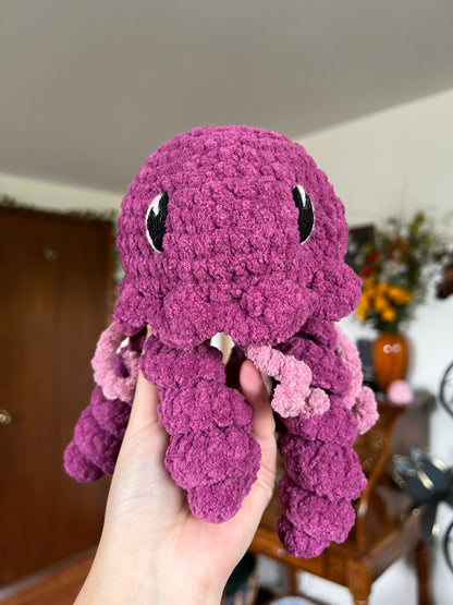Crochet jellyfish in a magenta and pink yarn with embroidered eyes