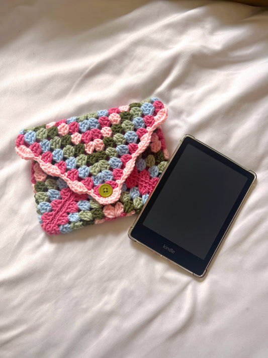 Crocheted pouch and Kindle on a white surface