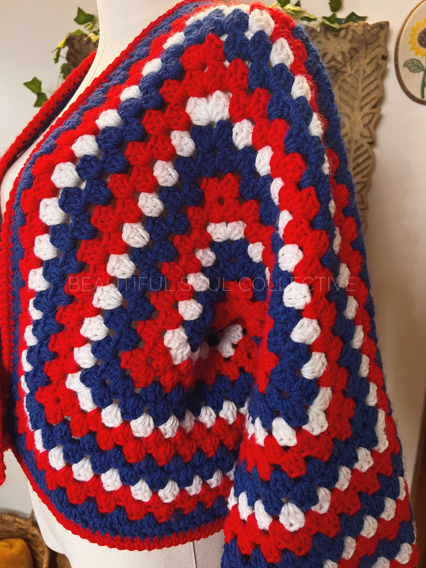 Crochet cardigan in red, white and blue yarn on a mannequin