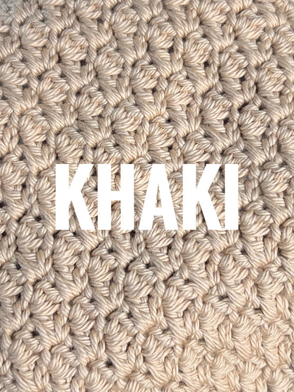 A close-up of a chunky crochet washcloth swatch in a warm khaki beige color, with the word 'KHAKI' overlaid in large white letters across the center.