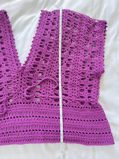 A purple crochet short sleeve top with measuring tape showing the length of garment