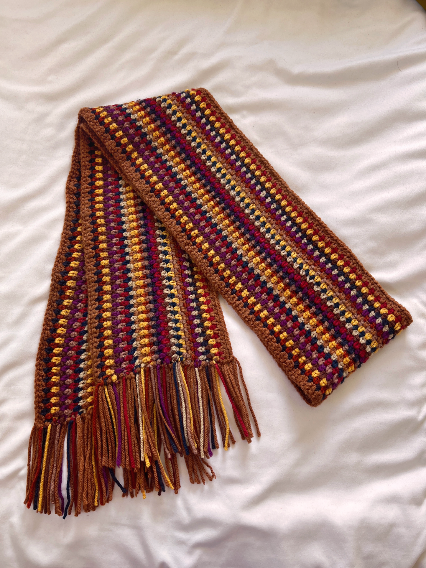 Warm toned handmade scarf on a white background