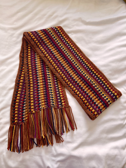 Warm toned handmade scarf on a white background