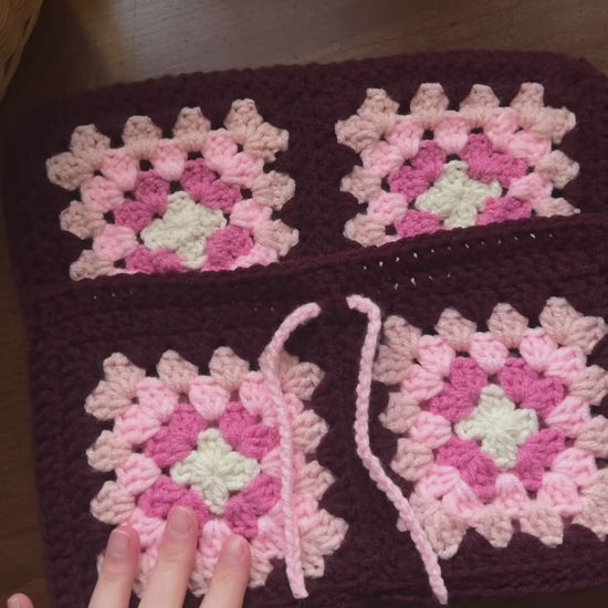 Person inserting books into handmade crochet book sleeve