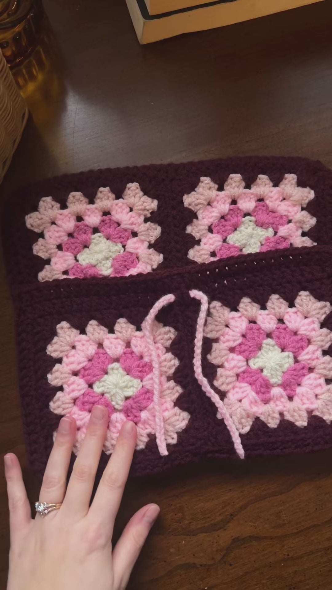 Person inserting books into handmade crochet book sleeve