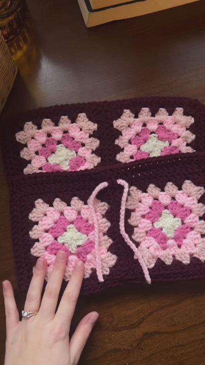 Person inserting books into handmade crochet book sleeve