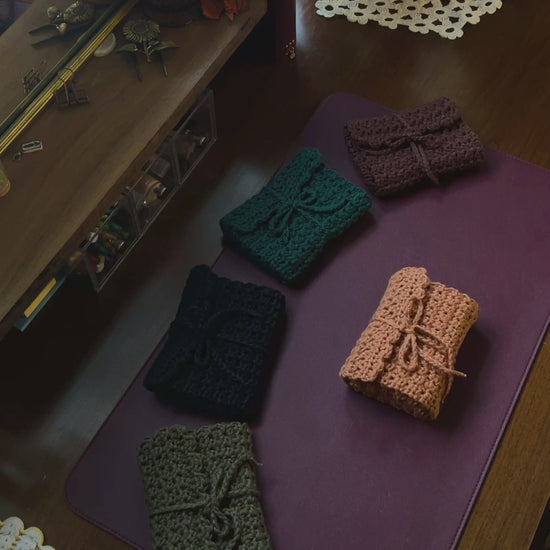 Crochet Tarot Card Roll-Up cases on a desk with purple mat and decor